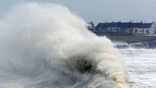 <p>Waves crash over Garrettstown, Co Cork. File picture: Denis Minihane.</p>