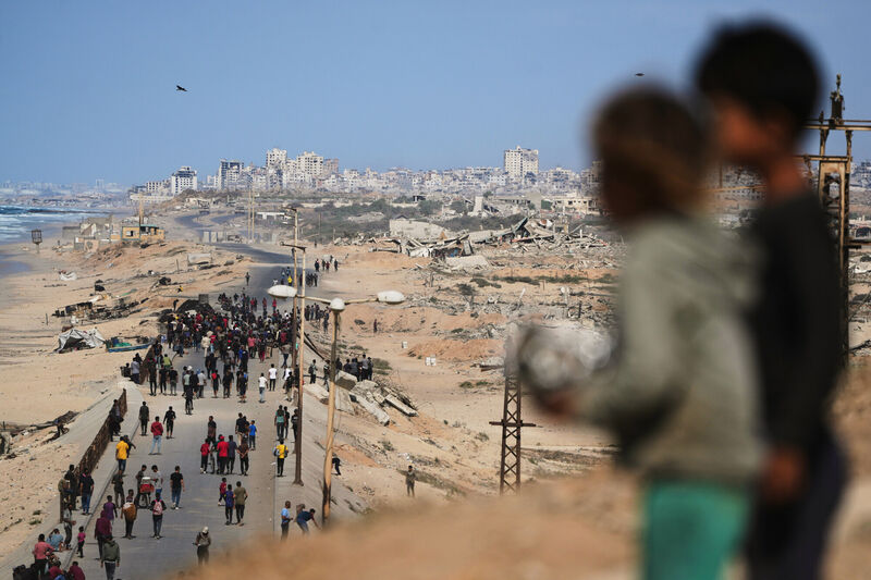 Displaced Palestinians gather on the coastal road near Wadi Gaza after the announcement Israel and Hamas had agreed to the first phase of a peace plan to pause the fighting, as Israeli tanks block the road leading to Gaza City. Picture: AP /Abdel Kareem Hana