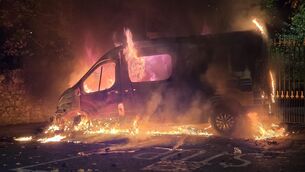 <p> A garda van on fire outside Citywest Hotel, Saggart tonight. Picture; Collins</p>