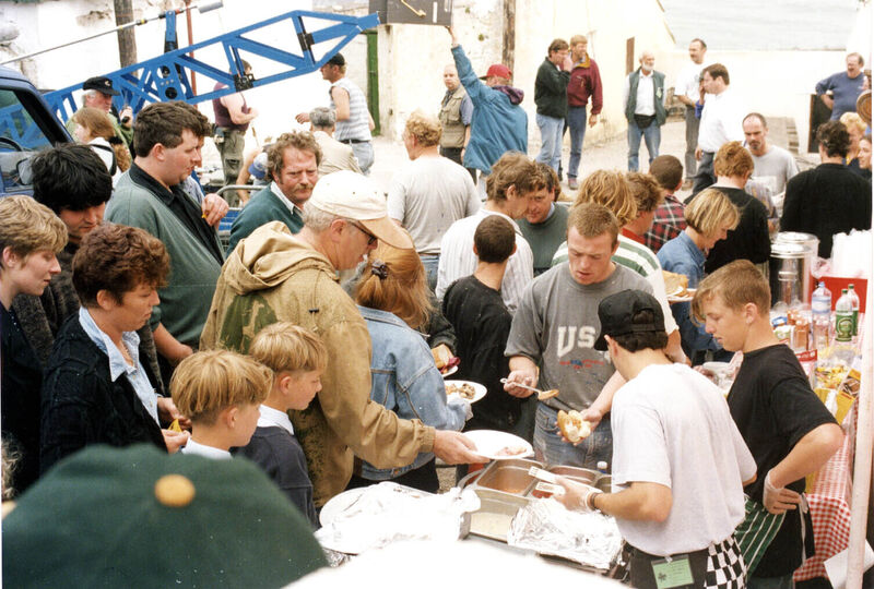 Director Thom Eberhardt (with baseball cap) and cast and crew members pausing for lunch during the shooting of 'Divine Rapture' in Ballycotton, Co Cork, in 1995. Picture: Irish Examiner Archive