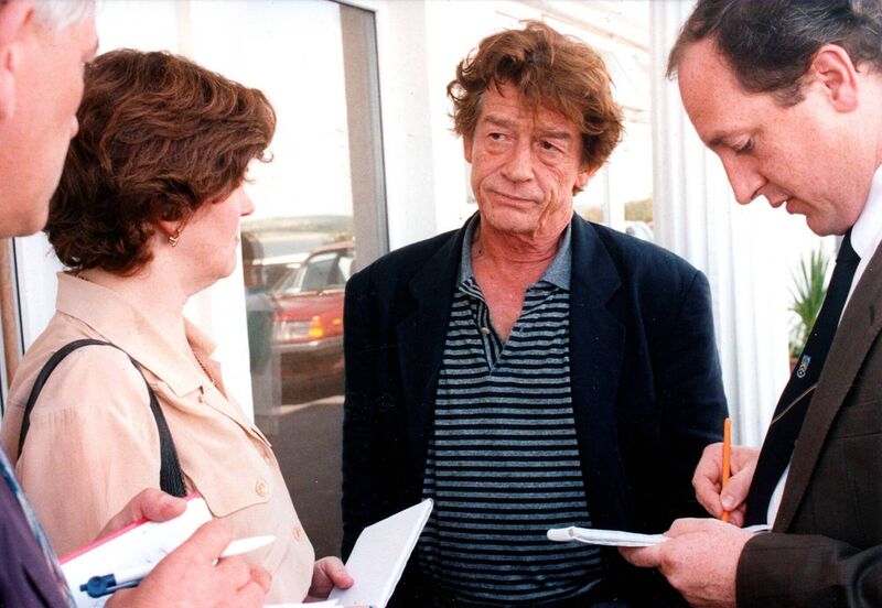 Actor John Hurt speaking with Ann Cahill from the 'Irish Examiner' and Maurice Gubbins of 'The Echo' during the 'Divine Rapture' shoot in Ballycotton, Co Cork, in July 1995. Picture: Irish Examiner Archive
