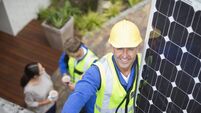 Worker installing solar panel on roof