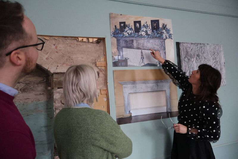 Crawford staff member Dyane Hanrahan points out the details of one of the building's fireplaces. 