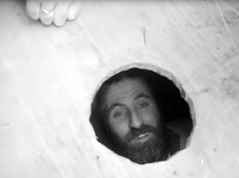 Mick Meaney peering from the coffin in which he spent 61 days buried alive in Kilburn, London.