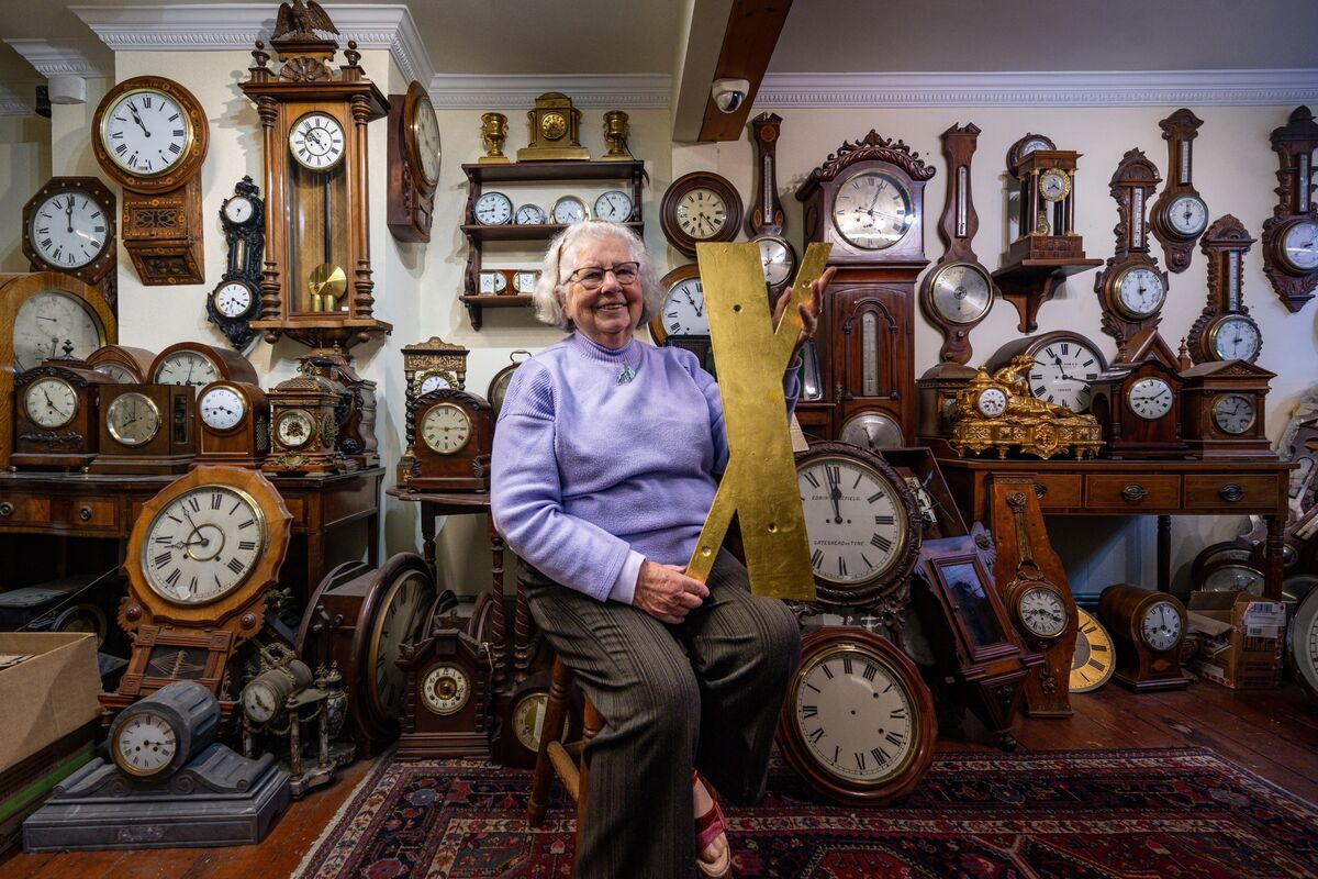 Sitting among a wall of timepieces in Stokes Clocks on MacCurtain Street, Sally Stokes holds a completed numeral destined for Shandon's four-faced liar, reflecting decades of gold-leafing expertise. Picture: Chani Anderson