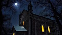 Church at night with lights in the windows under the moonlight