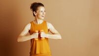 Cheerful Woman with Dumbbells in Orange Activewear