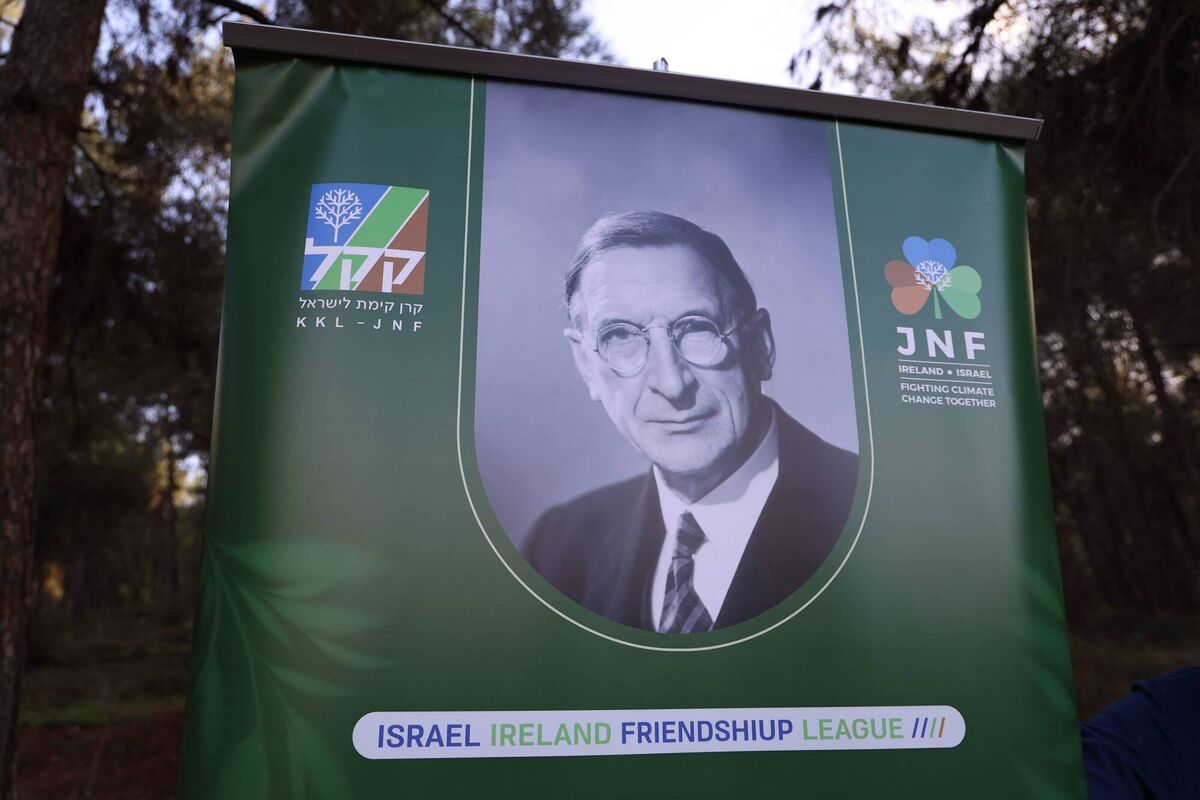In lieu of the engraved white marble plaque, a colourful printed sign with an austere image of de Valera and a shamrock logo in the blue and green and brown colours of KKL-JNF above the slogan: 'Ireland * Israel | Fighting climate change together.'