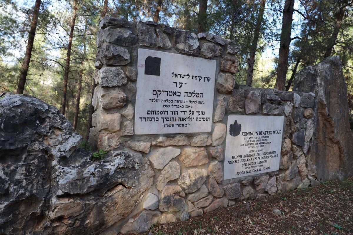 In the middle of the open area surrounded by pine trees is a large commemorative wall dedicated to Queen Beatrice and Princess Julianna of the Netherlands.