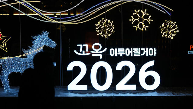 <p>A man walks by illuminated decorations on New Year's Eve in Seoul, South Korea. Picture: Lee Jin-man/AP</p>