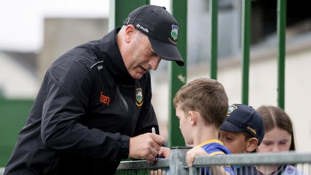 <p>Tipperary manager Liam Cahill signs autographs before the game. Pic: ©INPHO/Laszlo Geczo.</p>