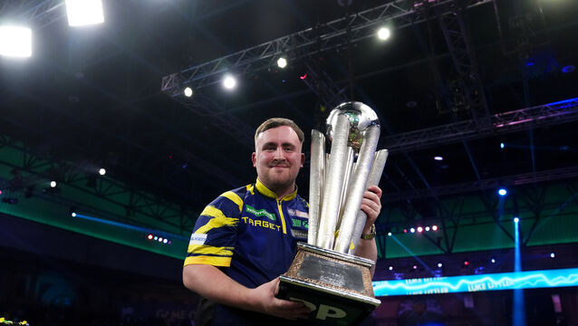 Luke Littler celebrates with the Sid Waddell trophy after victory against Gian van Veen in the final of the World Darts Championship at Alexandra Palace (John Walton/PA)