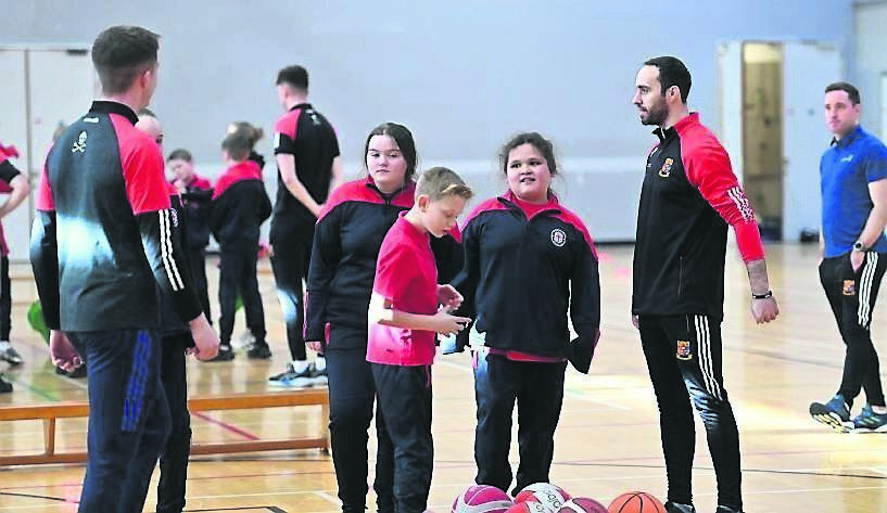 Conor Philpott and Diarmuid Lester with some of the pupils from Scoil Padre Pio at the UCC School of Education with Barr na gCnoc learning Irish through sport at the Mardyke Arena. Picture: Dan Linehan