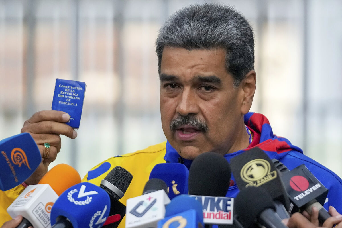 Nicolas Maduro displays a mini edition of Venezuela's constitution after voting in the presidential elections in 2024. Picture: AP Photo/Fernando Vergara