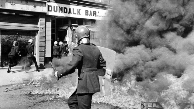 <p>Gardaí chasing suspects after petrol bombs were launched as Peter Robinson and his supporters marched through Clontibret, Co Monaghan in August, 1986. Picture: Alan Lewis/Photopress Belfast</p>