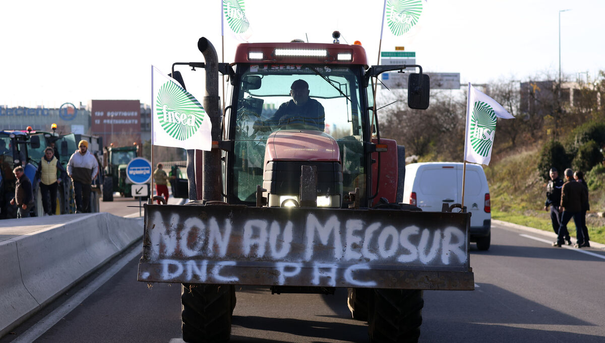A French farmer drives his tractor to block a main road during a protest against the Mercosur trade deal Dec. 18, 2025 in Portet-sur-Garonne, southwestern France. (AP Photo/Fred Scheiber)