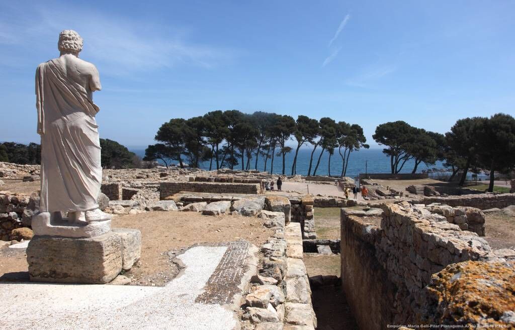 Sculpture of Asclepius in the foreground at the Greco-Roman ruins in Empúries, l'Escala