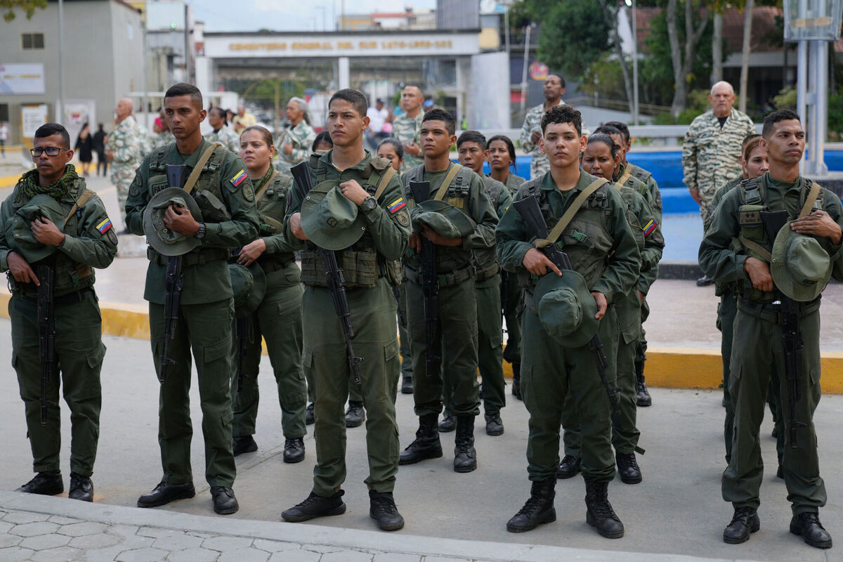 Military personnel remove their caps during the funeral of fellow soldiers killed in the US raid. Picture: Ariana Cubillos/AP Military personnel remove their caps during the funeral of fellow soldiers killed in the US raid. Picture: Ariana Cubillos/AP