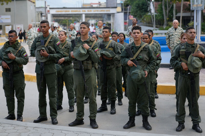 Military personnel remove their caps during the funeral of fellow soldiers killed in the US raid. Picture: Ariana Cubillos/AP