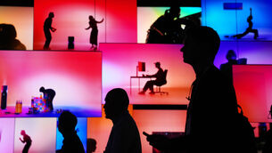 People pass an LG Electronics display during the CES tech show (Abbie Parr/AP)