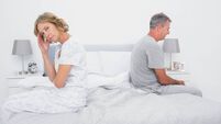 Annoyed couple sitting on different sides of bed