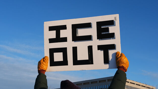 <p>A protester holds up a sign saying ‘Ice out’ (Adam Gray/AP)</p>