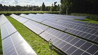 Aerial Drone Shot Of Engineers Inspecting Solar Panels In Field Generating Renewable Energy