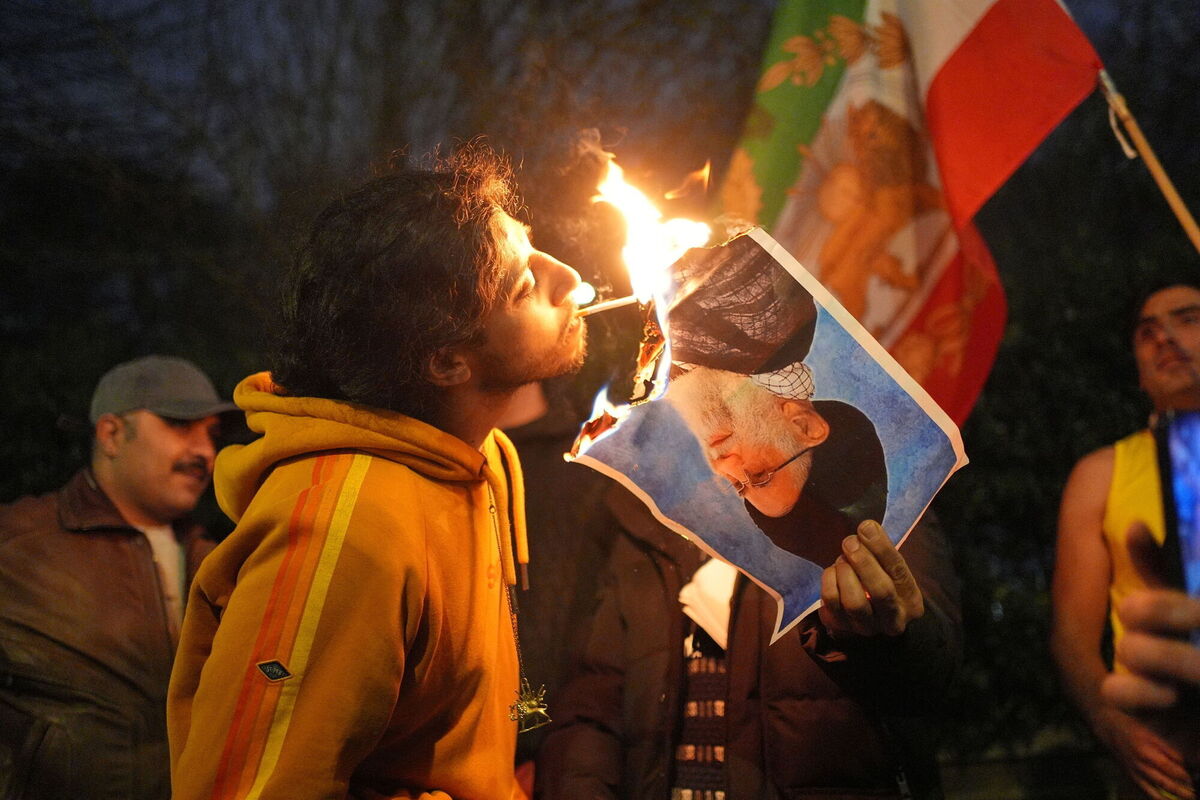 A picture of Iran's Supreme Leader Ayatollah Ali Khamenei is used to light a cigarette after being set alight by a protester outside the Iranian embassy, in London. 