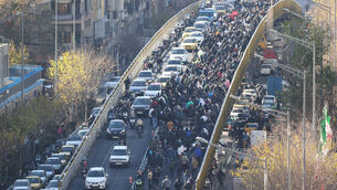 <p>Protesters march on a bridge in Tehran (Fars News Agency via AP)</p>