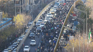 <p>Protesters march on a bridge in Tehran (Fars News Agency via AP)</p>