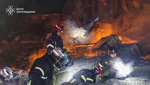 Emergency services personnel work to extinguish a fire following a Russian attack in Kharkiv (Ukrainian Emergency Service via AP)