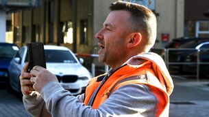 <p>Derek Blighe video records a cameraman outside Cork District Court before his appearance on Tuesday.</p>