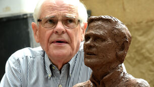 <p>Seán Ó Sé looks over the ceramic bust of himself, created by sculptor Sean MacCarthy at the National Sculpture Factory, Cork in 2017. Picture: Larry Cummins </p>
