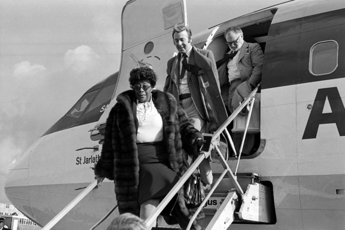 Pearse Harvey accompanying Ella Fitzgerald off the plane in Cork as she arrived for the jazz festival in 1980. Picture: Irish Examiner Archive
