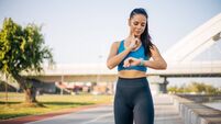 A young fitness woman checks her pulse on her neck.
