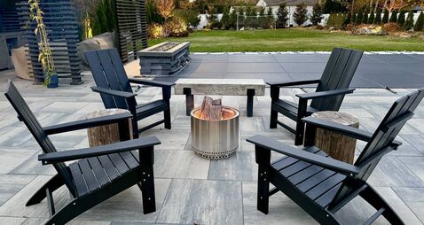 Outdoor sitting area fire pit in a chilly New York backyard in the fall. Enjoy landscaping, foliage and beauty while staying war