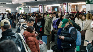 <p>Passengers wait in the hall of Madrid train station on Sunday. Picture: Carlos Lujan/AP</p>