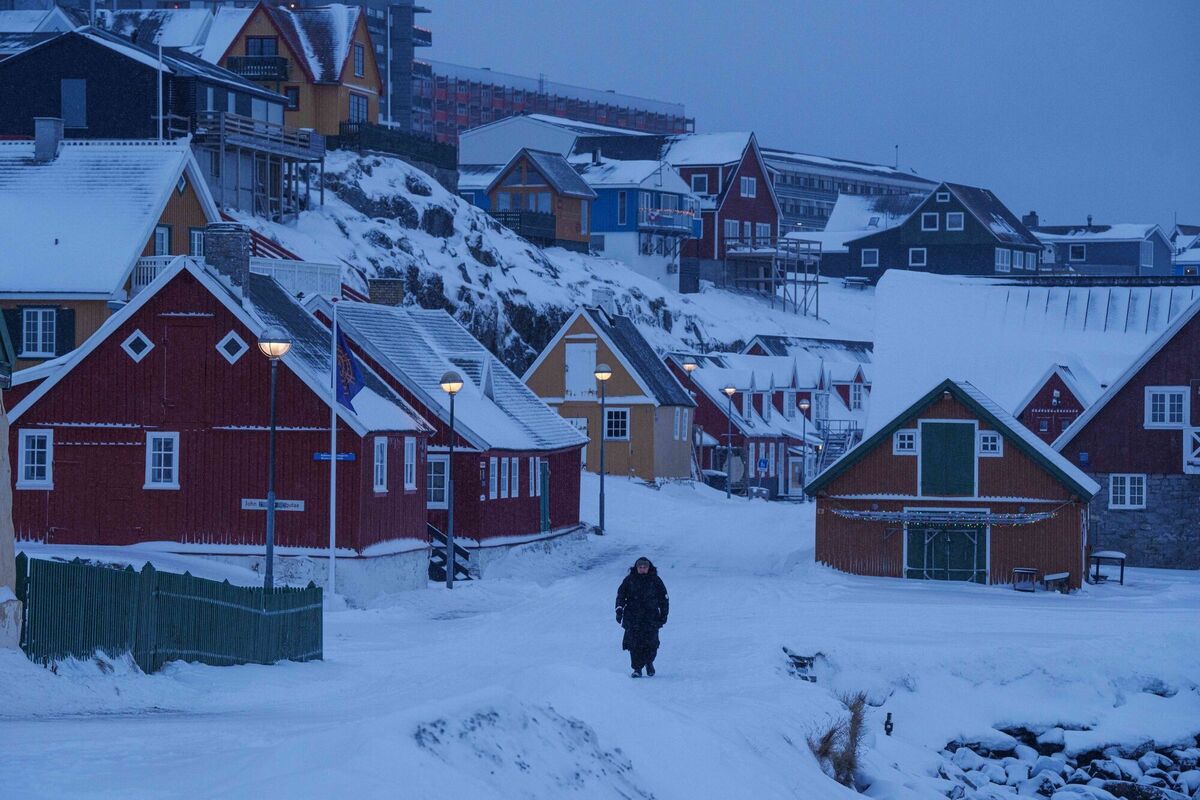 A person walks through a snow covered street in Nuuk, Greenland, Monday, Jan. 19, 2026. (AP Photo/Evgeniy Maloletka)