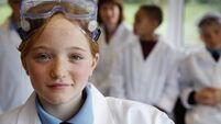 Schoolgirl (11-13) in science class, smiling, portrait (focus on girl)