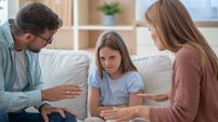 Parents arguing and scolding their sad daughter at home