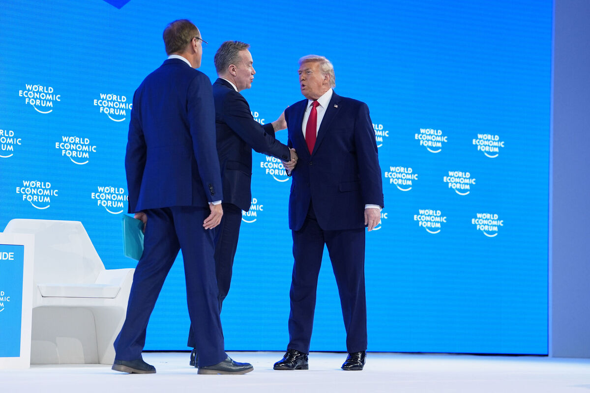 President Donald Trump, right, is introduced by World Economic Forum President Borge Brende, center, prior to addressing the audience during the Annual Meeting of the World Economic Forum in Davos, Switzerland, Wednesday, Jan. 21, 2026. (AP Photo/Evan Vucci)