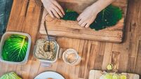 preparing vegan cabbage rolls on wooden kitchen board