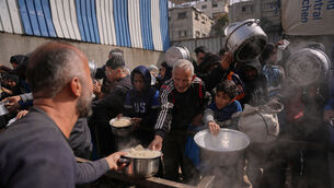 <p>Palestinians receive donated food at a community kitchen in Nuseirat, in central Gaza on Saturday. Picture: Abdel Kareem Hana/AP</p>
