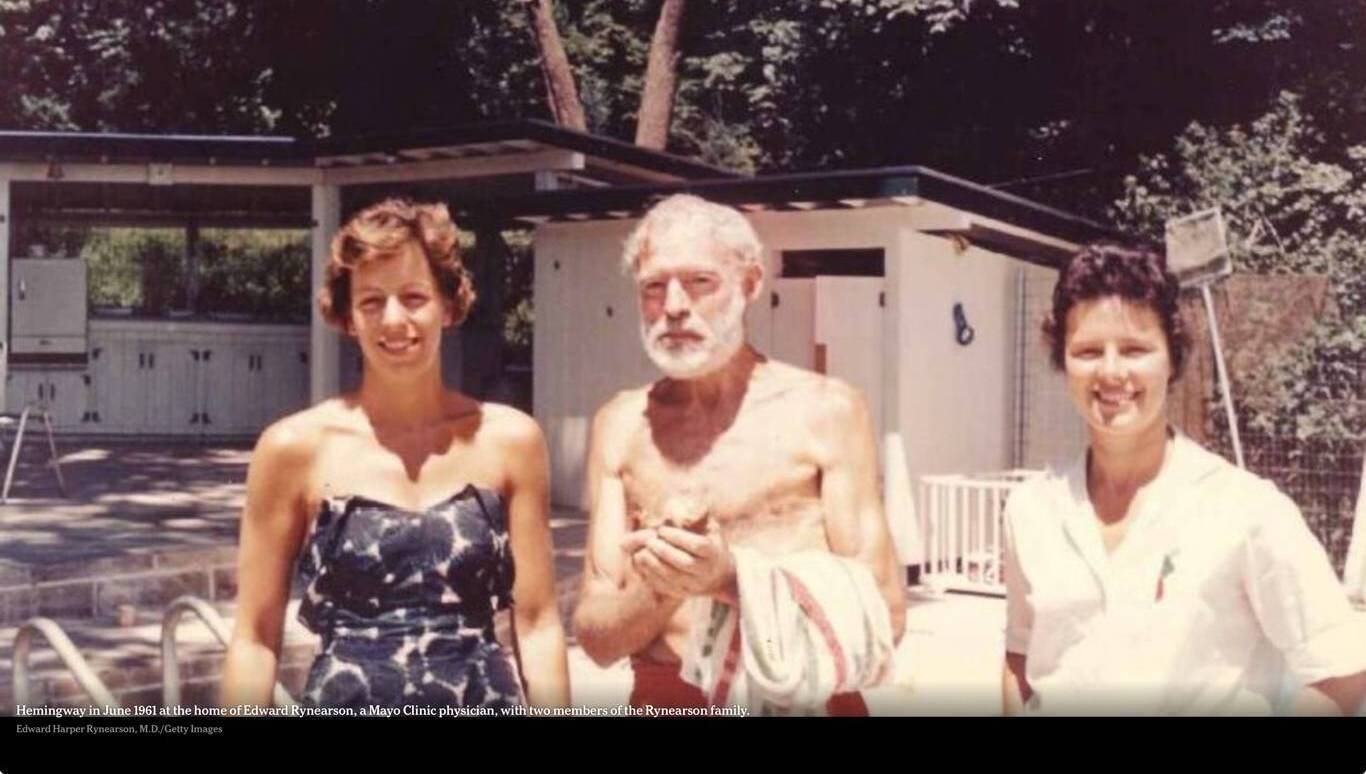 Ernest Hemingway in June 1961 at the home of a Mayo Clinic doctor with two members of the doctor's family. He hardly exists and — at 61 years of age — looks so fragile and shrunken, he could be two decades older.