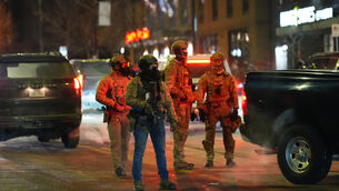 <p>Federal agents stand guard as they try to clear the demonstrators near a hotel during a noise demonstration protest in response to federal immigration enforcement operations in the city Sunday, Jan. 25, 2026, in Minneapolis. (AP Photo/Adam Gray)</p>