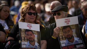 People in Tel Aviv, Israel, hold signs with a photo of Ran Gvili, who was killed while fighting Hamas militants during the October 7 2023 attack (Leo Correa/AP)