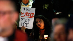<p>A demonstrator holds a sign during a candlelight vigil during a protest in response to the fatal shooting of 37-year-old Alex Pretti in Minneapolis. Picture: AP Photo/Caroline Brehman.</p>