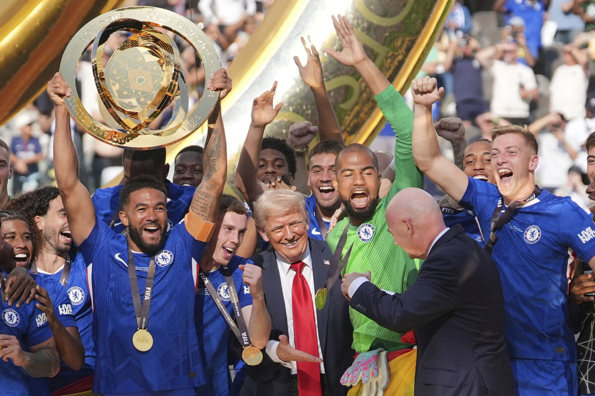 President Donald Trump reaches out to shake hands with FIFA President Gianni Infantino as Chelsea's Reece James lifts the trophy following the Club World Cup final. Pic:AP Photo/Seth Wenig.