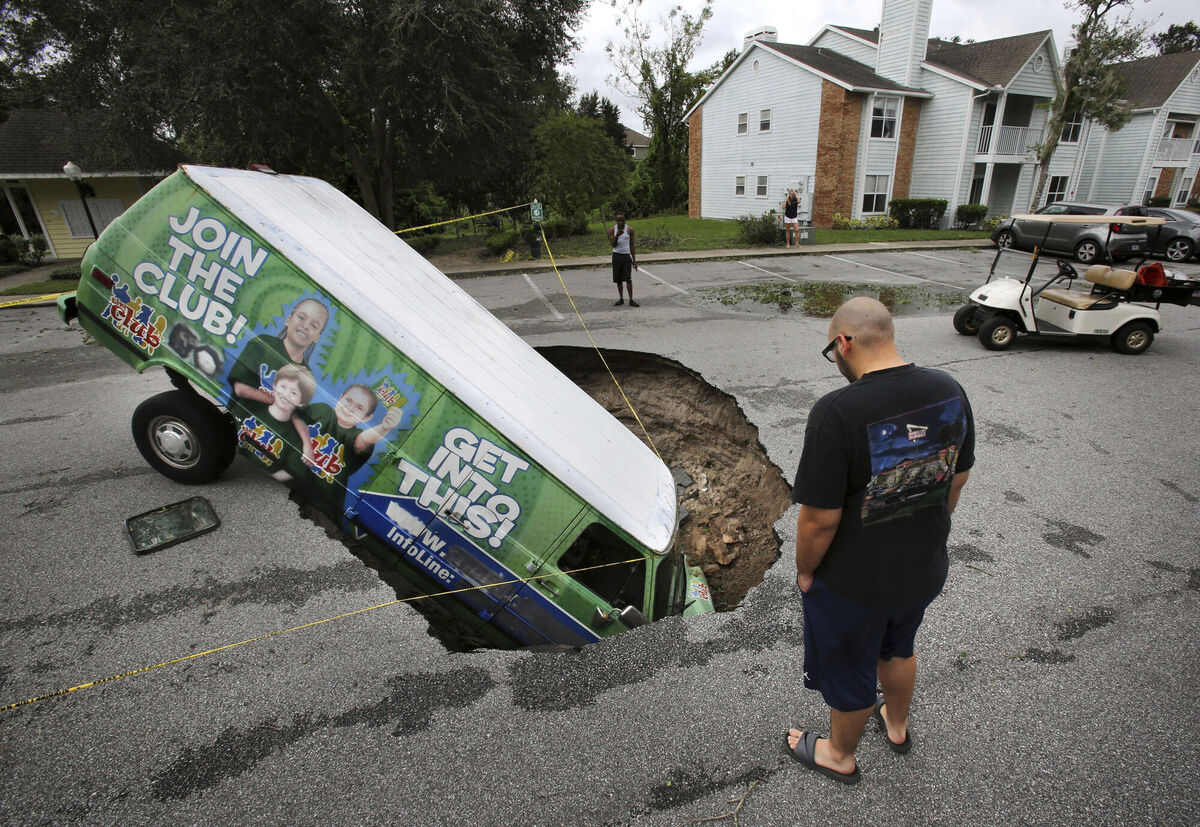 A van remains in a sinkhole, Monday, Sept. 11, 2017, that opened up at the Astor Park apartment complex in Winter Springs, Florida, during Hurricane Irma's passing through central Florida. The glass on the ground (left) is the window that the driver punched out to extract himself after driving into the sinkhole. Picture: Joe Burbank/Orlando Sentinel via AP