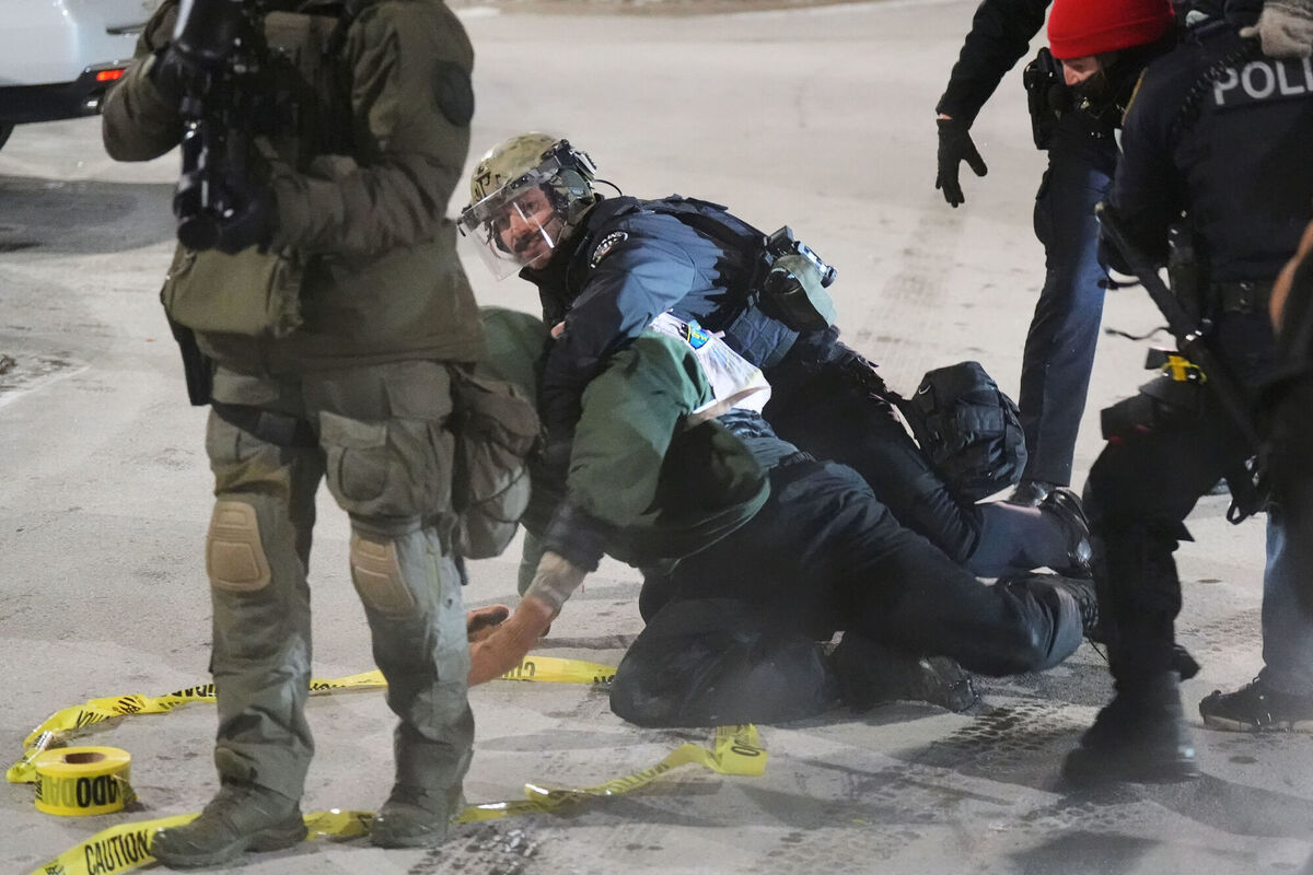 Law enforcement officers detain demonstrators during a protest outside SpringHill Suites and Residence Inn by Marriott hotels on Monday, Jan. 26, 2026, in Maple Grove, Minn. (AP Photo/Adam Gray)